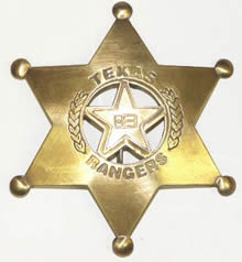 A brass sheriff's star shaped badge with the circle star shape in the middle with the Texas Flag in the middle of the star, branches on the sides of the circle, and the words "Texas Ranger" on the top and bottom.