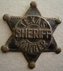 A bronze sheriff's shaped badge with the words "Texas Sheriff Ranger" on it.