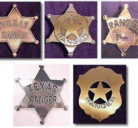 Five badges, four in the shape of a sheriff's star badge and one in the shape of a shield with a star in the center.