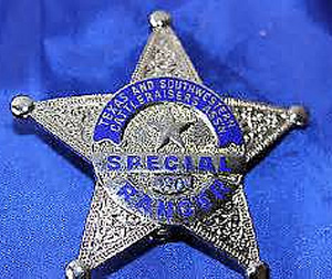 A silver star badge with a blue circle in the center with the words "Texas and Southwestern Cattleraisers Assn" across the top of the circle. Across the