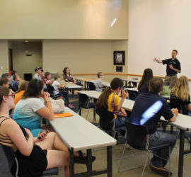 A group of children and adults at a presentation.