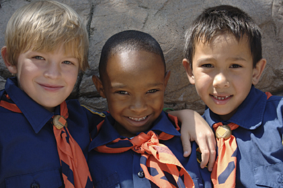 Three boys of diverse ethnic background in cub scout uniforms