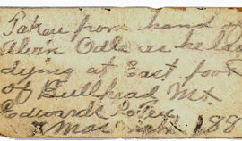 A handwritten note on off white aged paper.
