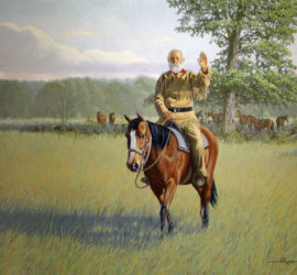 A man sitting on a horse with his hand raised in greeting.