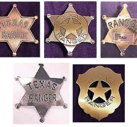 Five badges, four in the shape of a sheriff's star badge and one in the shape of a shield with a star in the center.