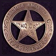 A silver circle star badge with the words "Frontier Battalion" along the top of the circle, "Texas Rangers" along the bottom, and "HQ Co." in the center of the star. There are swirls decorating the spaces without words.