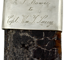 The silver cap of a black worn leather scabbard with the words "R. P. Bowie to Capt. Wm. Y. Lacy" engraved on it.