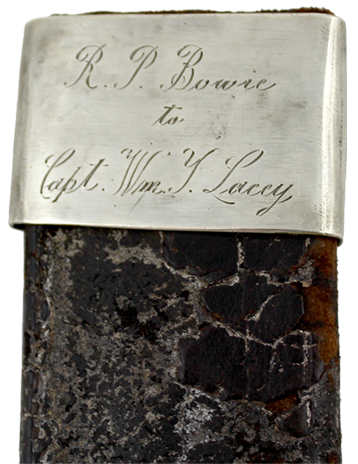 The silver cap of a black worn leather scabbard with the words "R. P. Bowie to Capt. Wm. Y. Lacy" engraved on it.