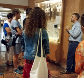 A male tour guide giving a tour two a group of people.
