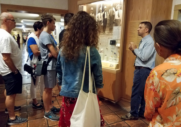 A male tour guide giving a tour two a group of people.