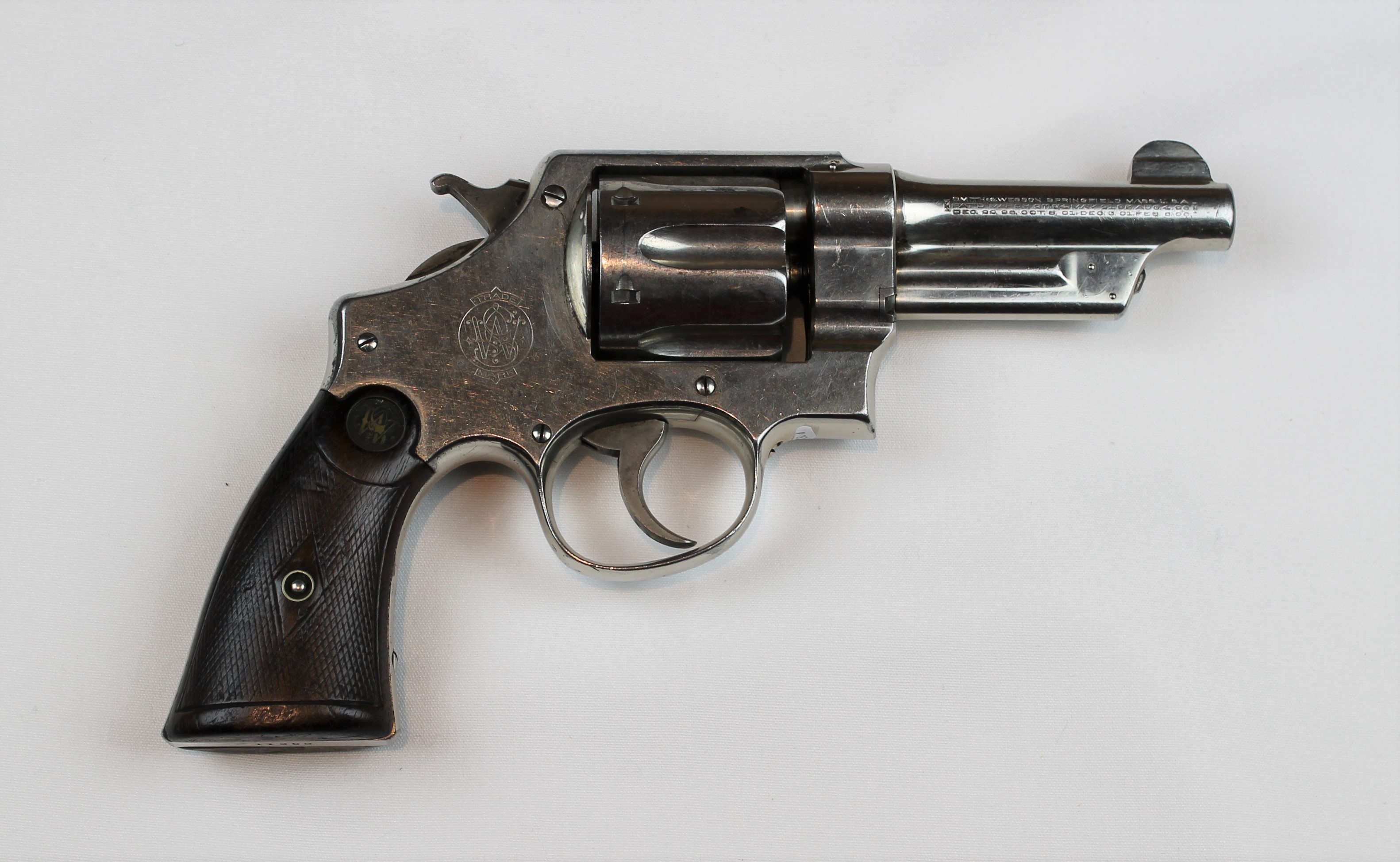 A silver metal revolver pistol with black grips.