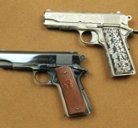 Two automatic pistols. One is a dark gunmetal color with wooden carved grips and the is a light silver colored metal with metal grips decorated with cacti and the words "Texas Ranger".