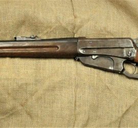 A rifle made up of a dark metal and lighter wood.