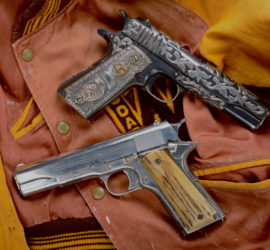 One simply decorated automatic pistol with a wooden or bone grip and one heavily decorative pistol on top of an orange letterman jacket.