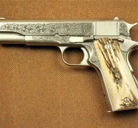 A silver automatic pistol with an antler grip and engraving along the silver parts of the gun.