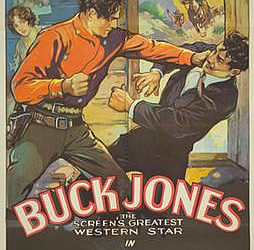 A man in a red shirt with a gun belt punching a man in a dark suit the words "Buck Jones The Screen's Greatest Western Star in "The Texas Ranger" printed at the bottom.