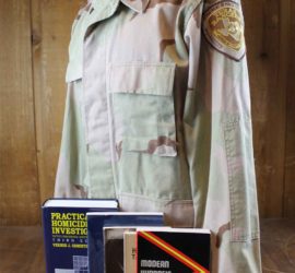 A camouflage uniform shirt with a Texas Ranger patch and four crime scene investigation text books.