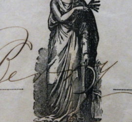 A black inked woman in a robe with a scythe and wheat in her hands. There is a decorative border below her and the edge of writing across her.