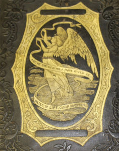 A gold embossed decoration of an angle holding a ribbon that reads "And he srewed me a pure river of water of life, clear as crystal in a gold decorative frame.