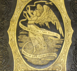 A gold embossed decoration of an angle holding a ribbon that reads "And he srewed me a pure river of water of life, clear as crystal in a gold decorative frame.