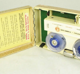 A tan recorder opened so you can see the two circles were the tape records along with instructions taped inside the lid.