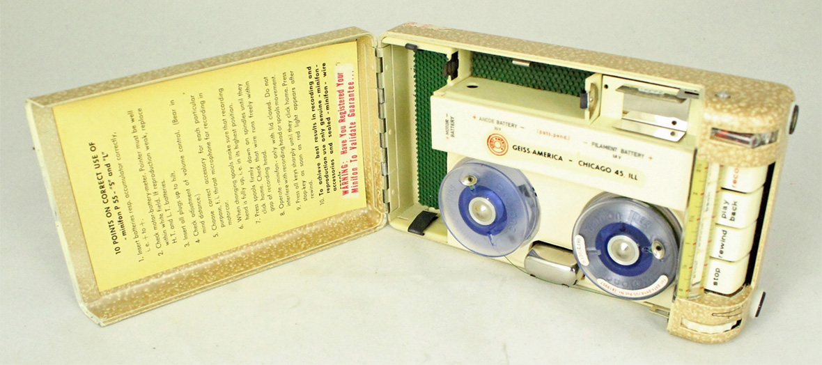 A tan recorder opened so you can see the two circles were the tape records along with instructions taped inside the lid.