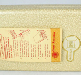 A speckled tan video recorder with instructions taped on the lid.
