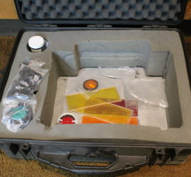 A padded box with various accessories in it such as colored lenses.