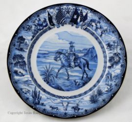 A blue inked white china plate with a cowboy on a horse in the middle, various Texas scenes along the edges, and the six flags of Texas at the top.