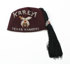 maroon hat with black tassle and embroidery