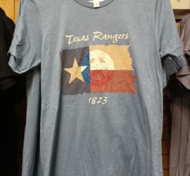 badge embossed over Texas flag on blue tshirt
