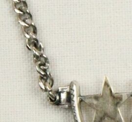 silver star connected to small bar and then a chain