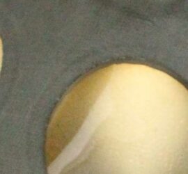 gray item with clear film covering circular cut-out