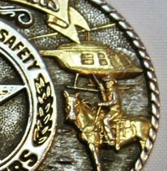 brass relief carving of horse and rider with helicopter and braided trim