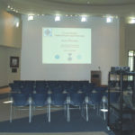 A PowerPoint presentation being projected in front of chairs set up theater style.