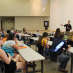 A group of children and adults at a presentation.